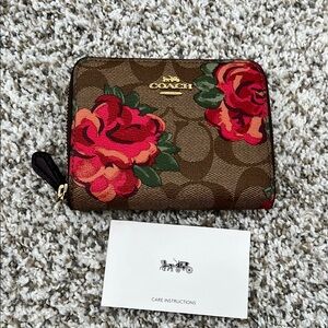 Coach zip wallet with logo and flowers.